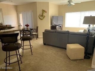 living area with light colored carpet and ceiling fan