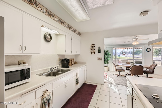 kitchen featuring sink, white cabinets, and light tile patterned flooring