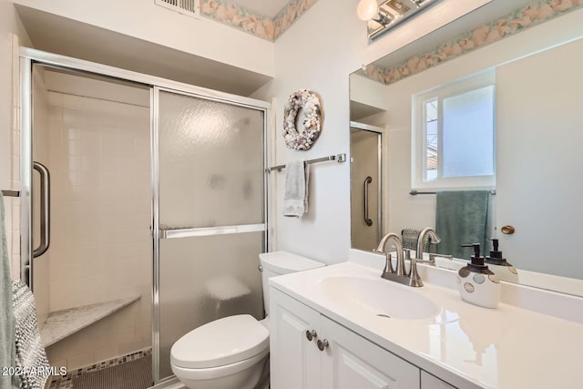 bathroom featuring vanity, toilet, and walk in shower