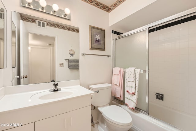 full bathroom featuring toilet, combined bath / shower with glass door, and vanity