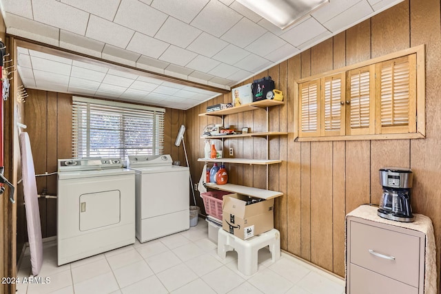 laundry room featuring separate washer and dryer and wooden walls