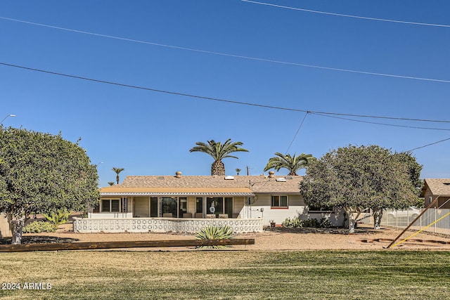 rear view of house featuring a yard