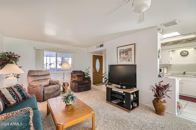 living room featuring sink, ceiling fan, and light tile patterned floors