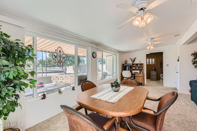 carpeted dining space with ceiling fan