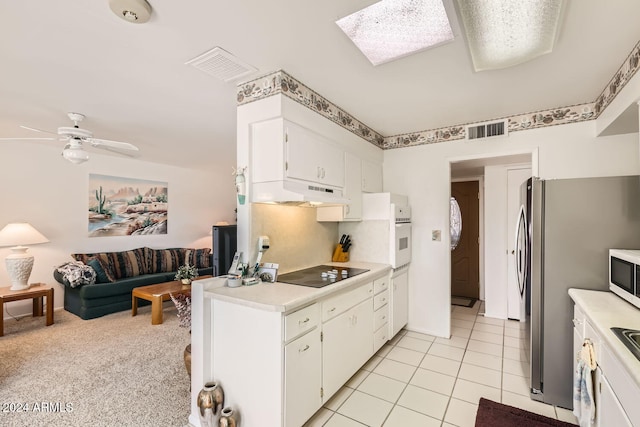 kitchen with light carpet, black electric cooktop, white cabinetry, and ceiling fan