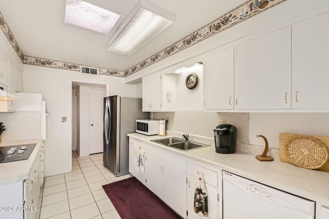 kitchen featuring sink, white cabinets, white appliances, and light tile patterned floors