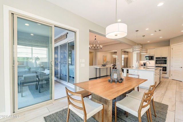 dining area featuring sink and a notable chandelier