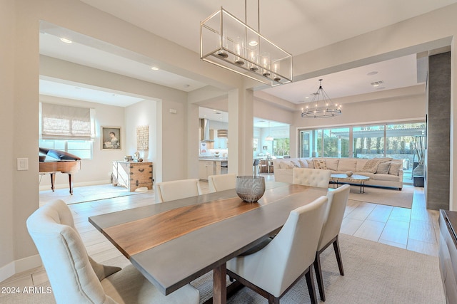 dining area with light tile patterned floors and an inviting chandelier