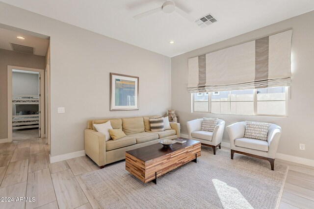 living room featuring ceiling fan and light hardwood / wood-style floors