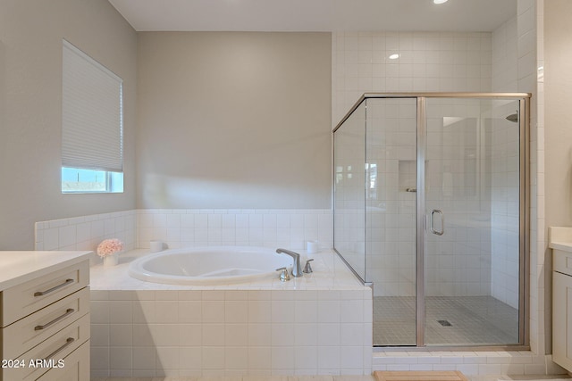 bathroom featuring shower with separate bathtub and vanity