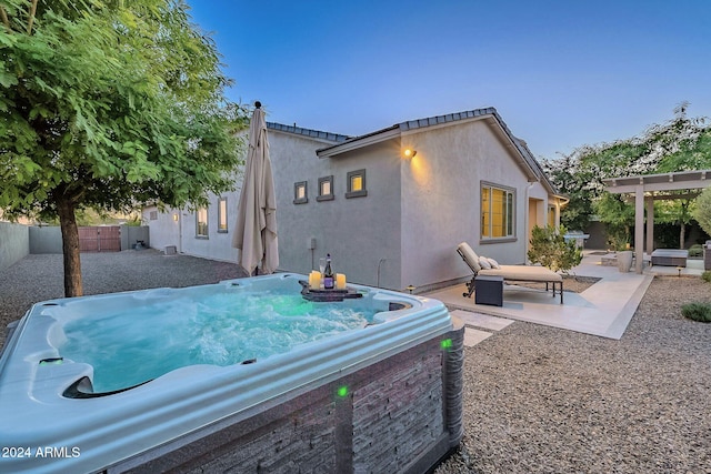 rear view of house with a patio, a hot tub, and a pergola