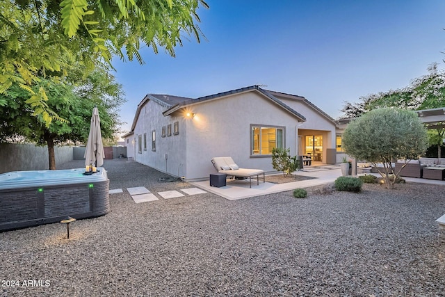 back of house featuring a hot tub and a patio