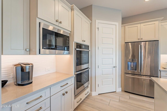 kitchen with white cabinetry, appliances with stainless steel finishes, and light wood-type flooring