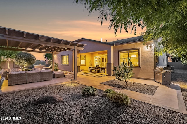 back house at dusk with an outdoor living space, a pergola, and a patio