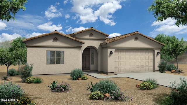 mediterranean / spanish-style home featuring an attached garage, concrete driveway, a tile roof, and stucco siding