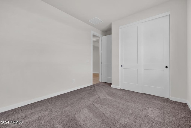 unfurnished bedroom featuring carpet flooring, baseboards, and a closet