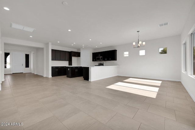 unfurnished living room with a chandelier, baseboards, recessed lighting, and light tile patterned flooring