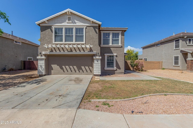 view of front of home with stucco siding, an attached garage, and fence