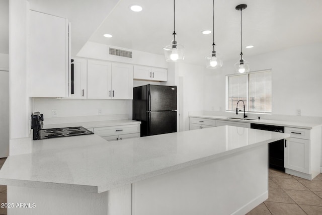 kitchen featuring a sink, a peninsula, light tile patterned floors, visible vents, and black appliances