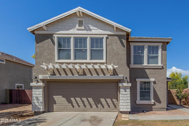 traditional-style house featuring stucco siding, concrete driveway, a garage, and fence