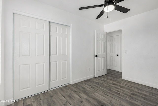 unfurnished bedroom with a ceiling fan, a closet, dark wood-style floors, and baseboards