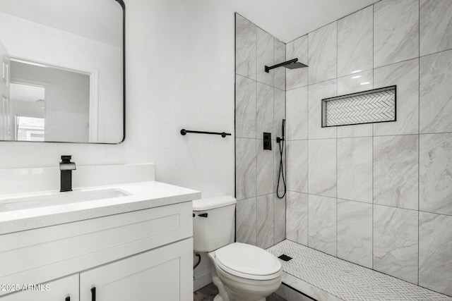 full bath featuring a tile shower, toilet, and vanity