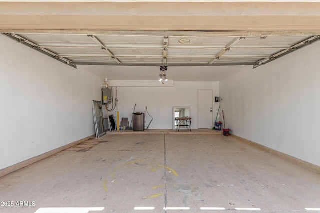 garage featuring baseboards and water heater