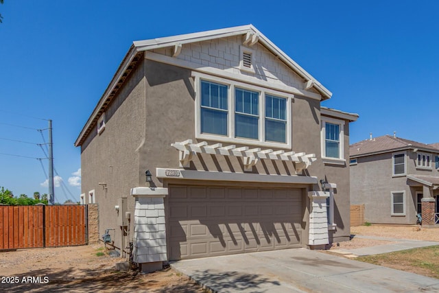 view of front of house featuring driveway, stucco siding, and fence