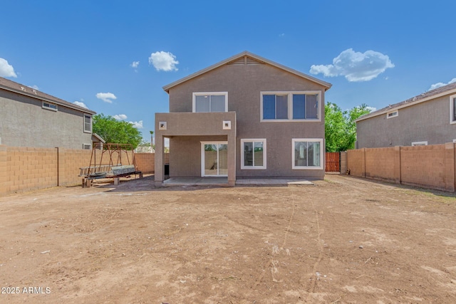 back of property with stucco siding, a fenced backyard, and a patio area