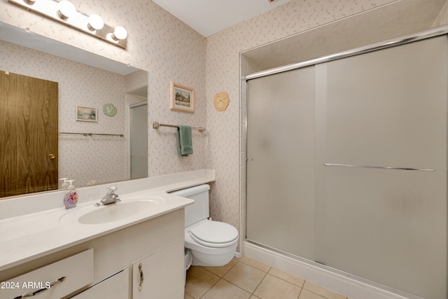 bathroom with tile patterned floors, vanity, toilet, and a shower with shower door