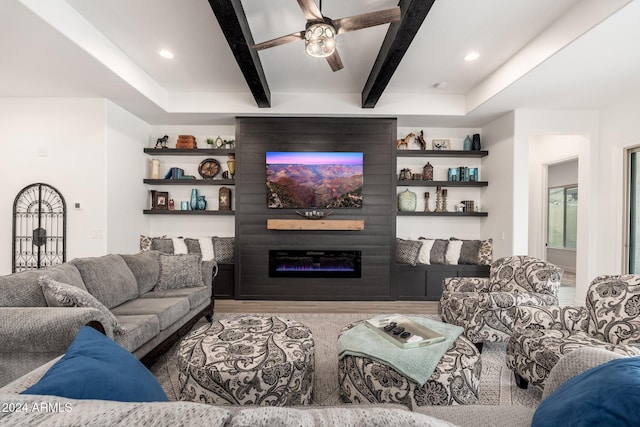 living room featuring beam ceiling, ceiling fan, a fireplace, and hardwood / wood-style flooring