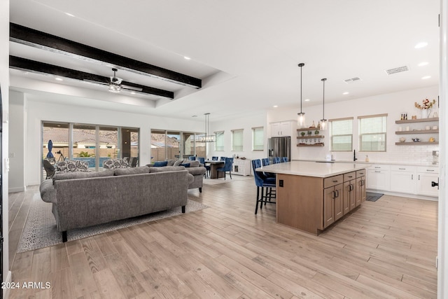 interior space with white cabinetry, plenty of natural light, ceiling fan, and a spacious island