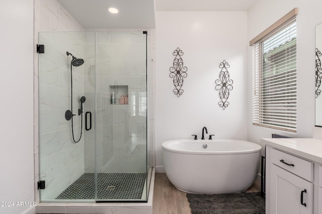 bathroom with vanity, wood-type flooring, and shower with separate bathtub