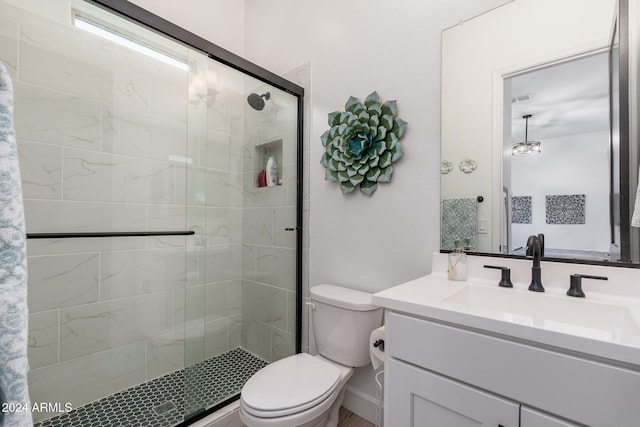 bathroom with vanity, a shower with shower door, and toilet