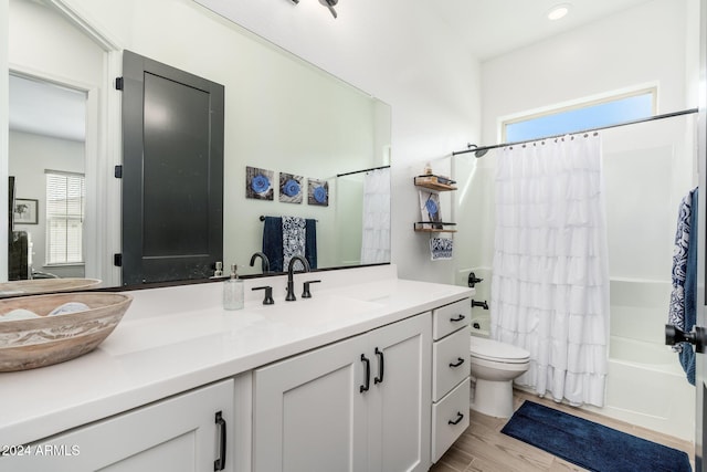 full bathroom featuring vanity, a healthy amount of sunlight, shower / tub combo, and hardwood / wood-style flooring