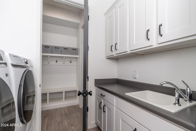 laundry room with cabinets, wood-type flooring, sink, and separate washer and dryer