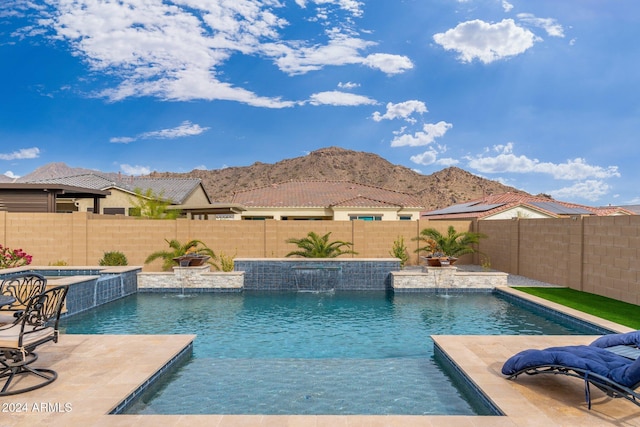 view of pool with pool water feature, a mountain view, and an in ground hot tub