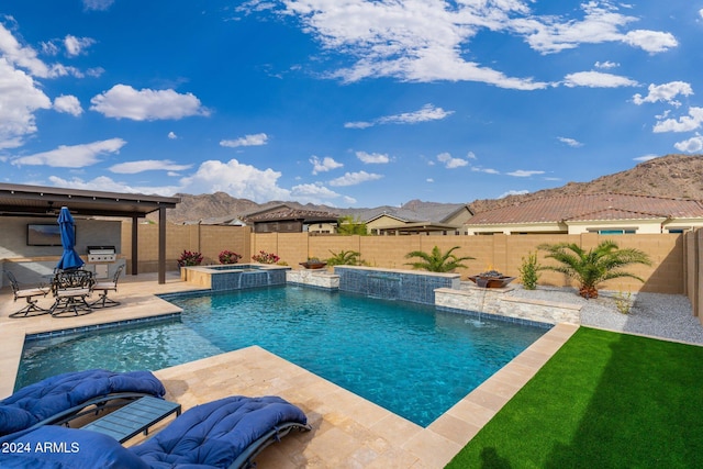 view of pool featuring a mountain view, pool water feature, an in ground hot tub, a grill, and a patio area