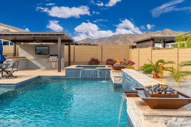 view of swimming pool featuring a mountain view, pool water feature, ceiling fan, an in ground hot tub, and area for grilling