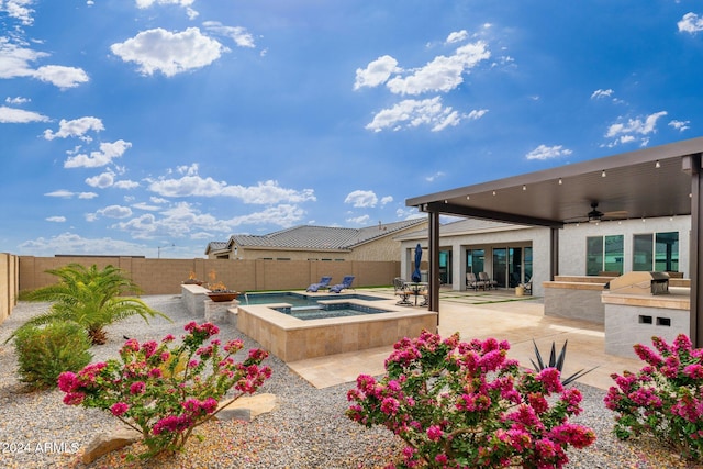 view of pool with an in ground hot tub, an outdoor kitchen, ceiling fan, and a patio area