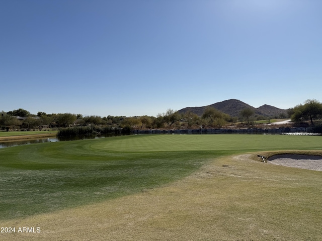 view of home's community with a water and mountain view and a lawn