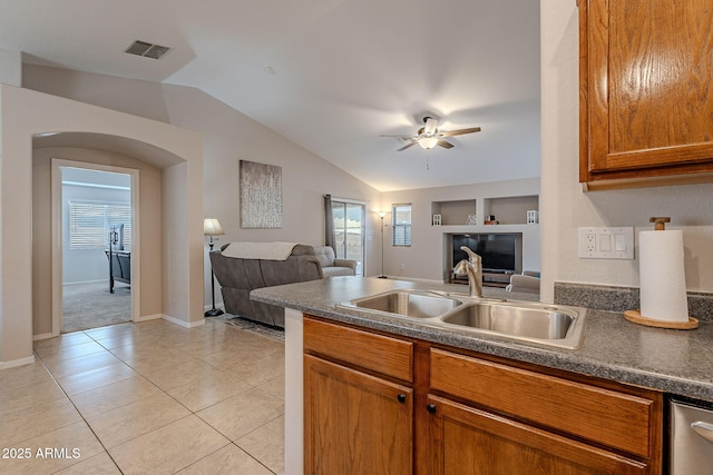 kitchen with sink, vaulted ceiling, a healthy amount of sunlight, and light tile patterned flooring