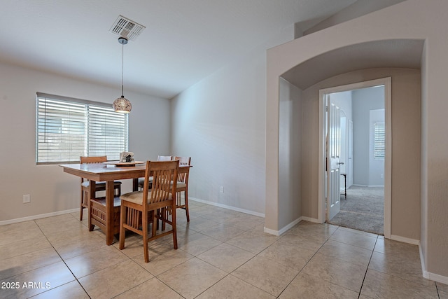 dining room with lofted ceiling and light tile patterned floors