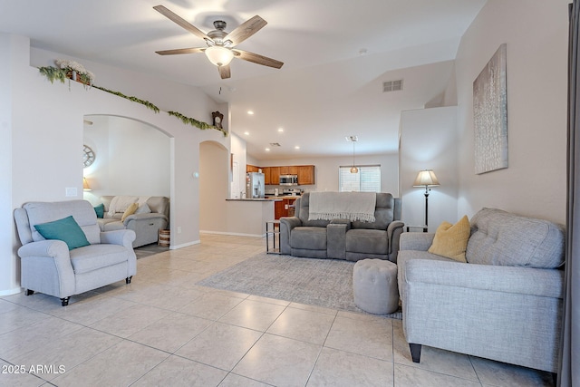 tiled living room featuring ceiling fan and vaulted ceiling