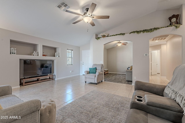 tiled living room with ceiling fan and vaulted ceiling