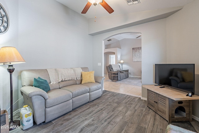 living room featuring hardwood / wood-style flooring, vaulted ceiling, and ceiling fan