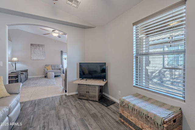 living room featuring lofted ceiling, hardwood / wood-style flooring, and ceiling fan