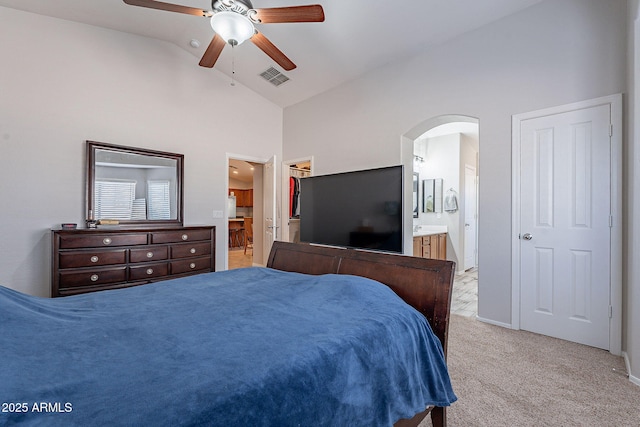 carpeted bedroom featuring ceiling fan, a walk in closet, connected bathroom, and high vaulted ceiling