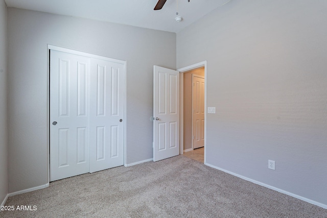 unfurnished bedroom featuring light carpet, a closet, and ceiling fan