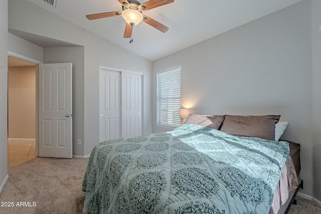 carpeted bedroom with vaulted ceiling, ceiling fan, and a closet